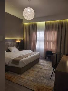 1 dormitorio con cama y lámpara de araña en فلل السيف الخاصة en Abha