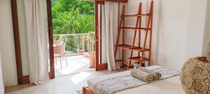 a living room with a book shelf and a balcony at Soraya Yoga Wellness Center in Gili Trawangan +170 photos