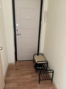 un couloir avec une chaise et une porte blanche dans l'établissement Апартаменты Балхаш, à Balkhach