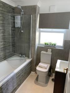 a bathroom with a toilet and a tub and a sink at TorquayTownhouse with Hot Tub 200m from Beach - Free WiFi Sky Glass in Torquay +60 photos