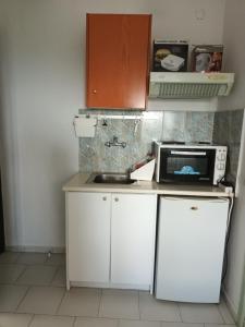 a small kitchen with a microwave and a sink at Pelagos in Stafylos