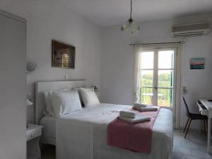 a bedroom with a bed with a desk and a window at Pelagos in Stafylos