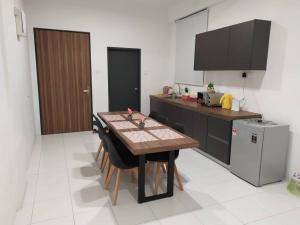 a kitchen with a wooden table and a refrigerator at Daddy's GuestHouse IMPERIO ALOR SETAR in Alor Setar