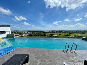 a large swimming pool with a view of the city at Daddy's GuestHouse IMPERIO ALOR SETAR in Alor Setar