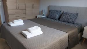 a bedroom with a bed with two towels on it at Gianni & Sophia airport house in Artemida