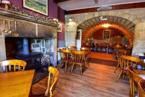 un restaurante con mesas y sillas y una chimenea en Robin Hood Inn en Hebden Bridge