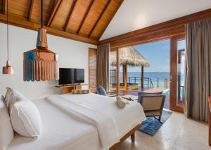 a bedroom with a bed and a view of the ocean at Furaveri Maldives - COMPLIMENTARY ROUND-TRIP SEAPLANE TRANSFER for two for a minimum of 5 nights or more from May 1st to October 31st, 2025 in Raa Atoll