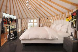 1 dormitorio con 1 cama blanca en una yurta en Gan-Hamlachim en Amirim