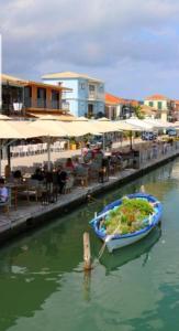 un barco en el agua junto a un restaurante en Seaview Kaposantes Apartments, en Lefkada