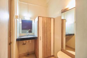 ein Bad mit einem Waschbecken und einem Spiegel in der Unterkunft Hotel Rajtara in Satara