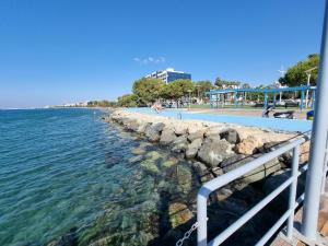 a beach with a retaining wall and the water at Kanika Beach apartment in Limassol