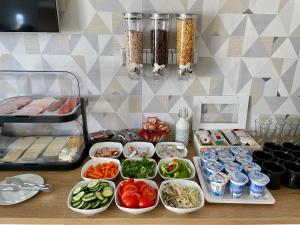 een tafel met kommen groenten en andere voedingsmiddelen bij Christina Residence in Boedapest