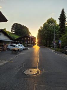 an empty street with the sun setting in the distance at Lakeside Interlaken Jungfrau in Därligen