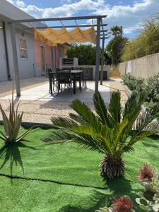 eine Terrasse mit einem Tisch und Stühlen im Hof in der Unterkunft Casa Sunshine - Casa Vacanze al mare in Punta Braccetto