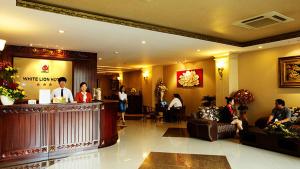 a hotel lobby with people sitting at a bar at White Lion Hotel in Ho Chi Minh City