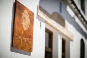 un cartel de madera en el lateral de un edificio en Alijar Casa Boutique, en Castilleja de la Cuesta