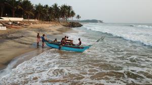 a group of people in a boat on the beach at Arabella on Boossa in Galle