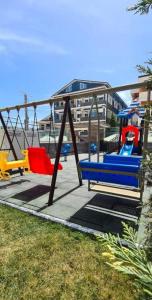 eine Schaukel mit zwei Stühlen auf einem Spielplatz in der Unterkunft Studiou Andu Nord 10 by Alezzi in Năvodari