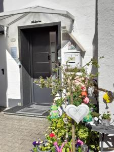 Eine Haustür eines Hauses mit einem Blumenstrauß. in der Unterkunft Ferienwohnung mit kleinem Garten in Sonnenbühl