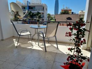 リマソールにあるIkaros Boutique Apartmentのバルコニー(テーブル、椅子2脚付)