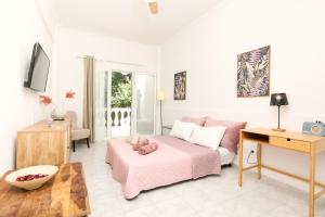a living room with a pink bed and a couch at Terranova beach apartment -Rose in Ýpsos