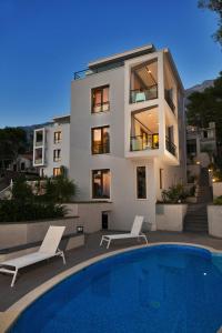 a house with a swimming pool in front of a building at Villa Paulina in Brela