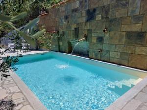 a swimming pool with a water fountain at Villa Desideri Agriturismo Dinoabbo in Lucinasco