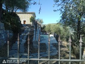 a stone path in front of a house with a fence at Villa Desideri Agriturismo Dinoabbo in Lucinasco