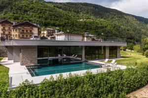 een huis met een zwembad voor een berg bij Gaia Residence Hotel in Mezzana
