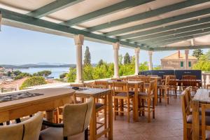 un restaurante con mesas y sillas y vistas al agua en Hostel Villa Skansi, en Hvar