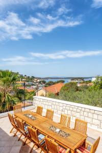 een houten tafel en stoelen op een patio met uitzicht op de oceaan bij Hostel Villa Skansi in Hvar