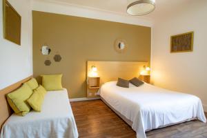 1 dormitorio con 2 camas y 2 lámparas en Hostellerie du Parc, en Cambo-les-Bains