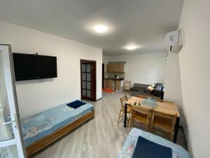 Habitación con 2 camas, mesa y TV. en Grand Like en Melʼniki