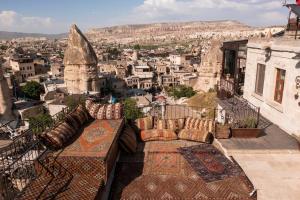 a balcony with pillows and a view of a city at Vista Cave Hotel in Göreme