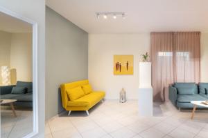 a living room with a yellow chair and two blue chairs at Menta Casa in Karteros