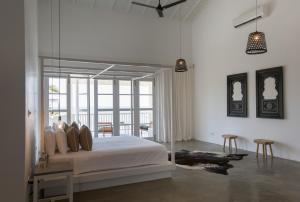 a bedroom with a bed and a large window at Arabella on Boossa in Galle