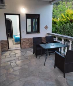 a patio with a table and chairs and a mirror at Pelagos Beachfront in Panormos Skopelos