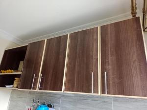 a row of wooden cabinets in a kitchen at Hossanah Furnished one bedroom in Kasarani,Nairobi in Nairobi