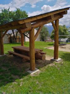 a wooden bench in a park with a roof at Superbe appartement neuf T3 6pers 45m2 in Font-Romeu-Odeillo-Via