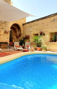 una gran piscina en un patio con una pared de piedra en bedroom buddha external bathroom, en Kerċem