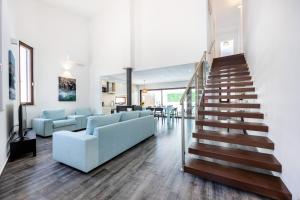 a staircase in a living room with a blue couch at Casa da Vuvu Montes de Alvor in Alvor