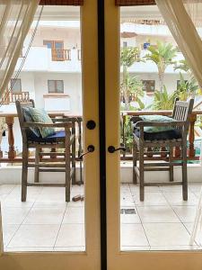 eine offene Tür zu einer Terrasse mit Stühlen und einem Tisch in der Unterkunft Modern Hamilton Cove Villa w/golf cart in Avalon