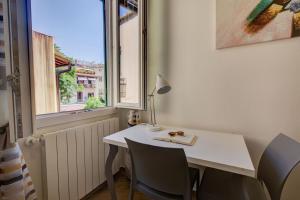 フィレンツェにあるFortezza Central Apartmentの白いデスク(椅子付)、ランプ、窓