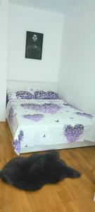 een slaapkamer met een bed met een zwart tapijt op de vloer bij RELAX LuX 2 in Jagodina
