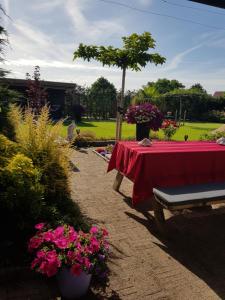 a table with a red table cloth and some flowers at B&B WELKOM Zierikzee in Zierikzee