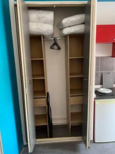 una puerta a un armario con estanterías y toallas en Studio 1 tout confort Avec wifi et Netflix, en Valenciennes