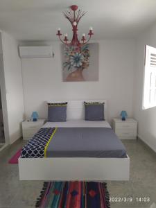 1 dormitorio con 1 cama y un jarrón en la pared en Charmant haut de villa 8 minutes de l'Hôpital de la Meynard, en Saint-Joseph