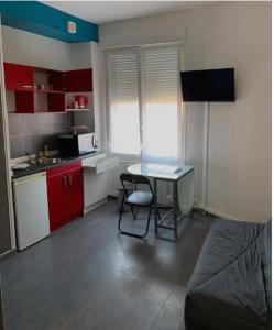 una pequeña cocina con escritorio en una habitación en Studio 1 tout confort Avec wifi et Netflix, en Valenciennes
