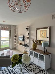 een woonkamer met een spiegel en een bank bij Apartment Sea Breeze – Apartamento Brisas del Mar in Benalmádena