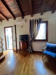 威尼斯的住宿－Romantic Rialto Apartment，客厅设有蓝色的沙发和窗户。
